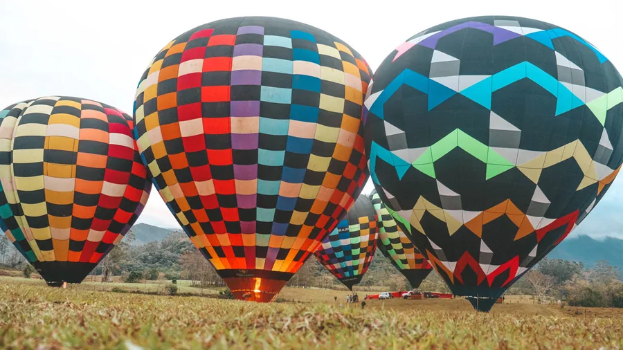 Quatro balões coloridos inflados no campo de decolagem em Praia Grande